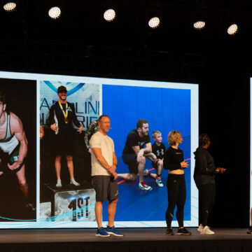Event-Photography Speakers on stage at Sacramento Convention Center event, engaging audience with visuals of athletic achievements, captured by Coldea Productions