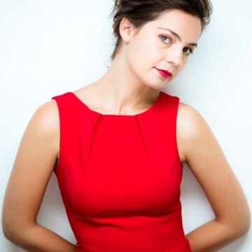 Maria-Dinulescu Professional headshot of a woman in a red dress against a white background, captured by Coldea Productions.