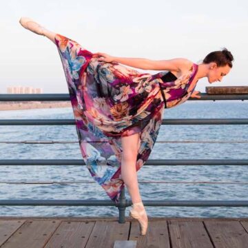 Coldea Productions captures the elegance of fashion and dance photography with a dancer posing in a floral dress on Santa Monica pier. This image emphasizes the beauty of movement and style in a natural, scenic setting.