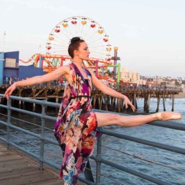 Ballet dancer in a floral dress performing on the Santa Monica Pier, captured by Coldea Productions in a blend of fashion and dance photography