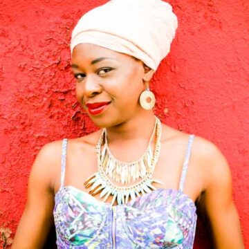 This vibrant portrait photograph by Coldea Productions features a woman posing confidently in stylish attire against a textured urban backdrop, showcasing their skills in professional portrait photography.