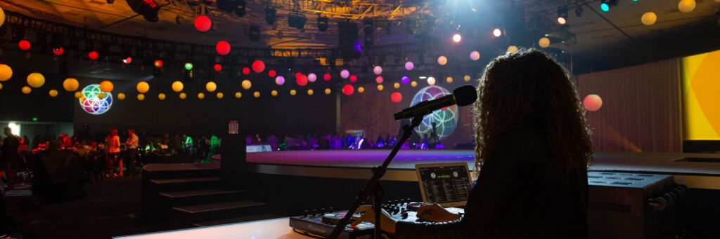 Conference-Photography DJ performing on stage with colorful lighting and decorations at a live event, captured by Coldea Productions, highlighting their event photography expertise.