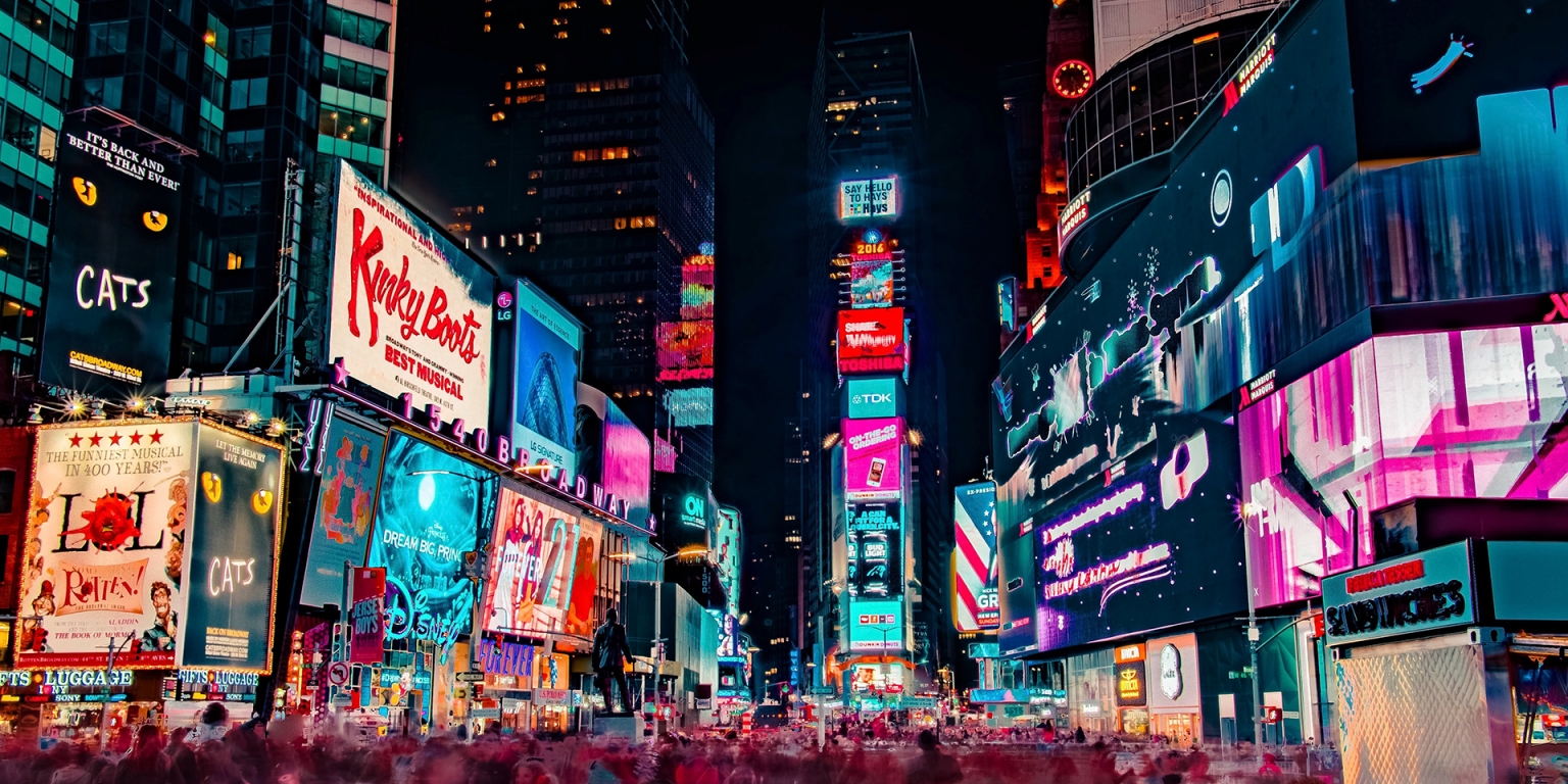 A vibrant view of Times Square at night showcasing illuminated advertisements and billboards, emphasizing the role of photography in advertising and marketing