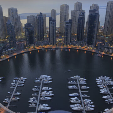 Aerial view of a luxury marina surrounded by high-rise buildings at dusk, showcasing Coldea Productions' aerial photography services.