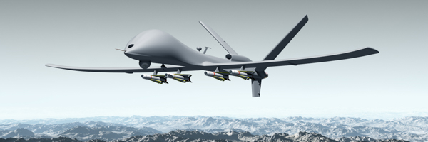 Unmanned combat aerial vehicle (UCAV) flying over mountainous terrain, featured in a drone video project by Coldea Productions for the US Navy in San Diego.