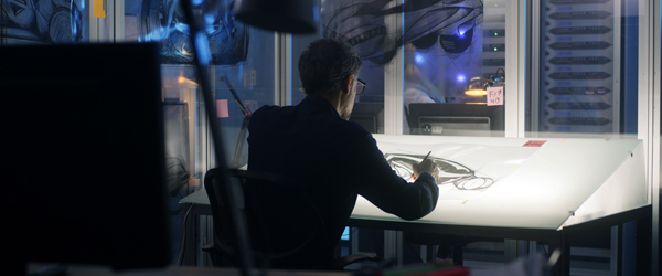 Animator focused on detailed sketches at a drawing board, showcasing Coldea Productions' expertise as a leading animated video production company.