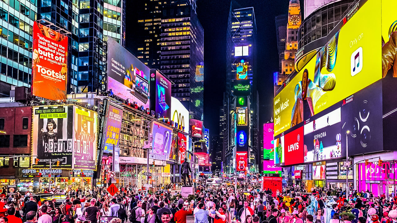 Vibrant Times Square at night filled with illuminated advertisements and crowds, showcasing branding and business visibility strategies