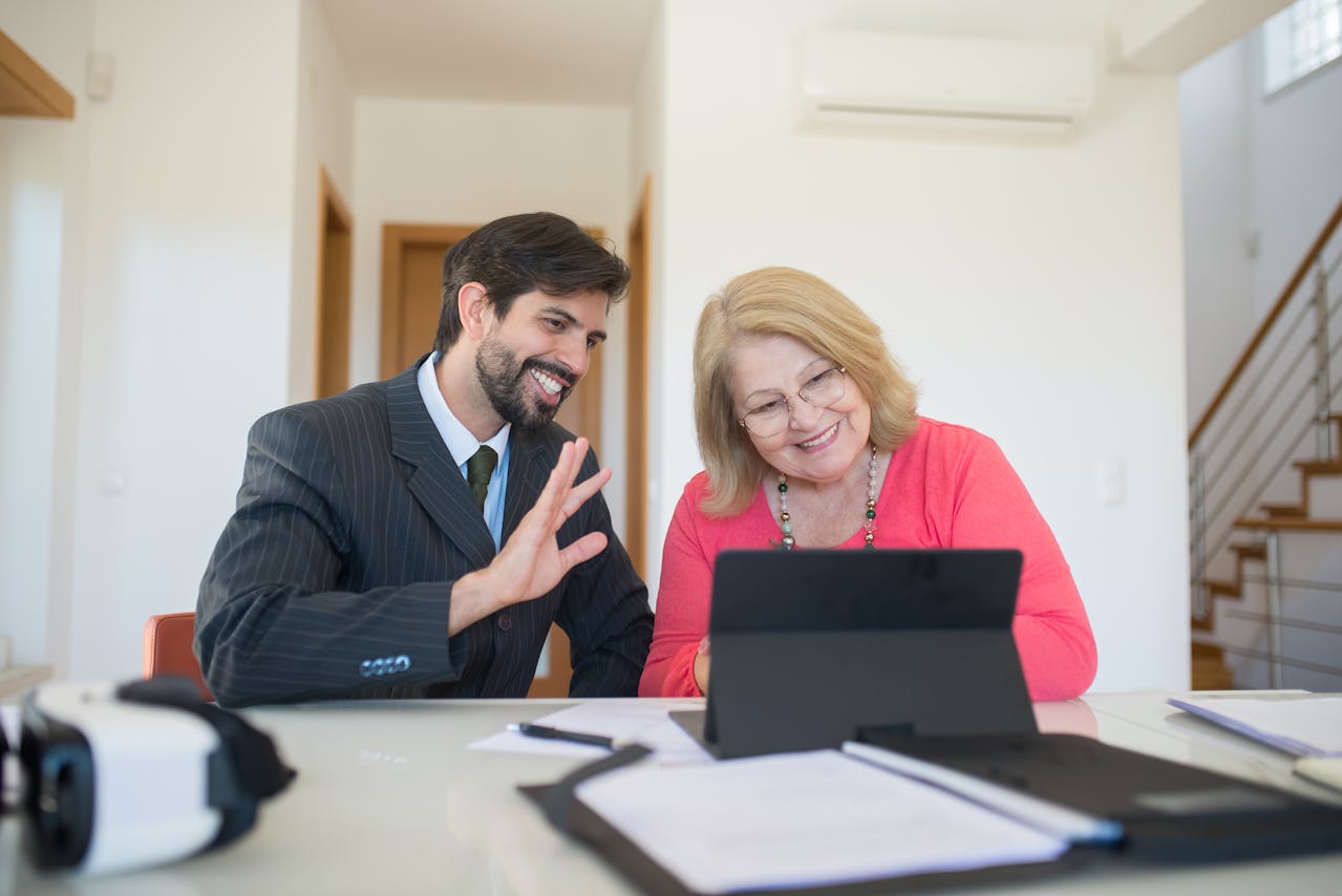 A real estate agent showing his client something on a tablet.