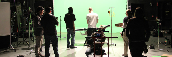 Film crew working on a green screen set for a video commercial production.