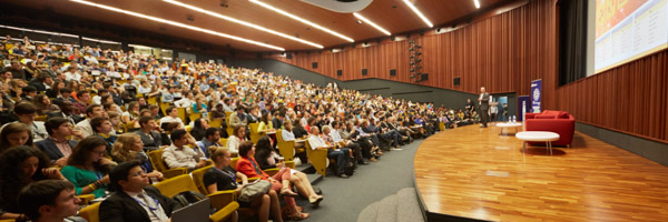 Wide-angle view of a large audience in an auditorium during a corporate event, ideal for nationwide photography services by Coldea Productions.