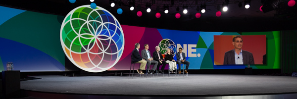 Panel discussion on a brightly lit stage with colorful visuals, captured during a professional event in Long Beach by Coldea Productions.