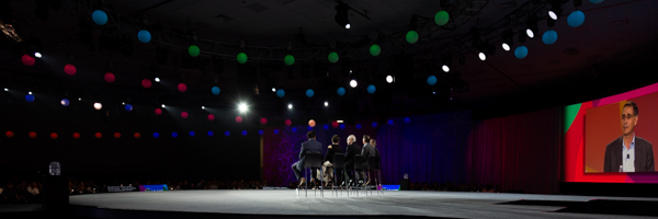 Wide-angle view of a panel discussion with vibrant stage lighting, ideal for event photography in Riverside, California, by Coldea Productions.