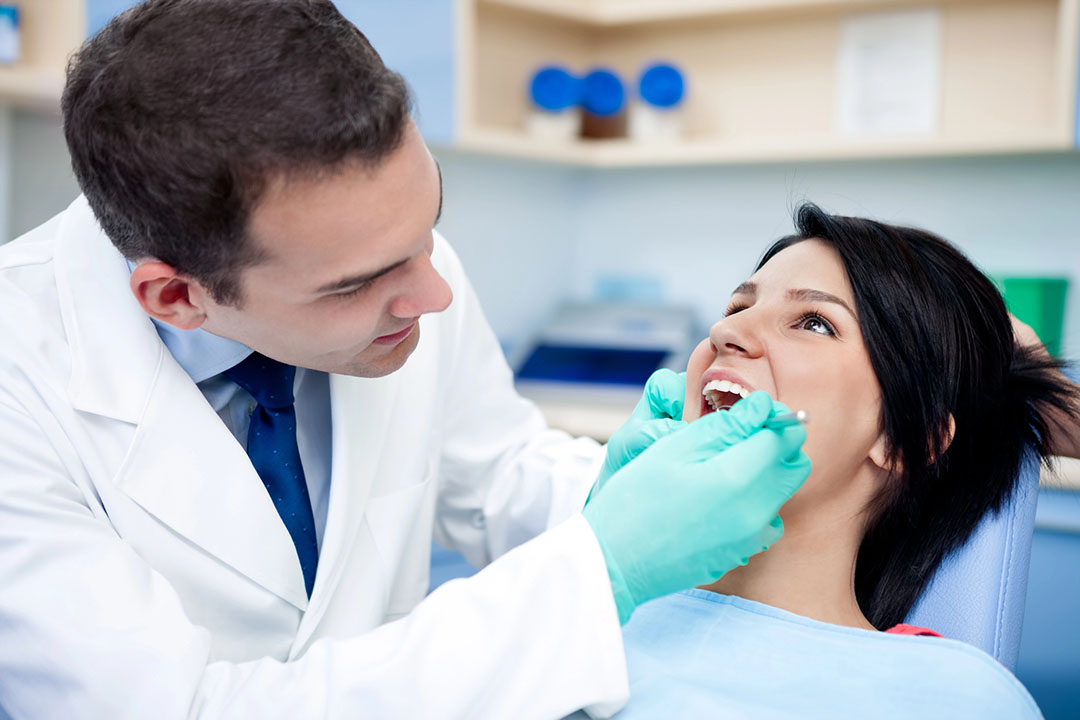 A professional dentist examining a patient's teeth, illustrating the importance of dental photography in enhancing patient care and building trust.