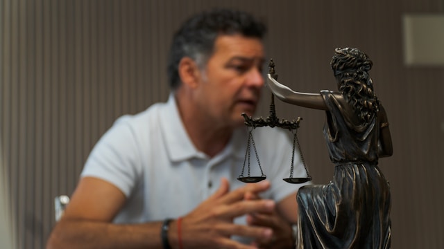 Professional discussing legal policy topics near a Lady Justice statue symbolizing fairness and advocacy.