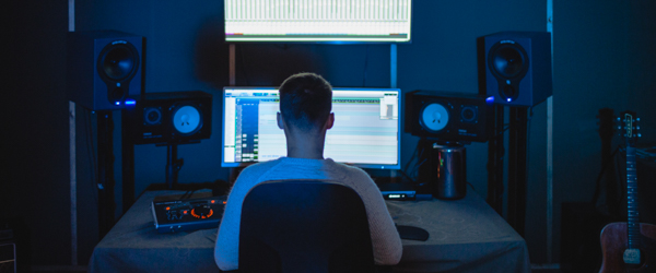 Video editor working in a professional studio with dual monitors and high-quality audio equipment, ideal for video production services in Phoenix, AZ, by Coldea Productions.