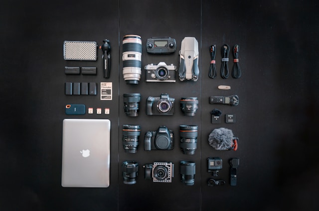 Flat lay of professional photography equipment and lenses arranged neatly on a dark background, symbolizing the tools behind brand identity and visual storytelling by Coldea Productions.
