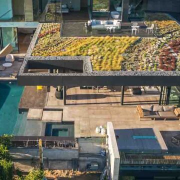 Aerial view of a modern luxury home with a green rooftop and pool area, showcasing Coldea Productions' real estate photography services