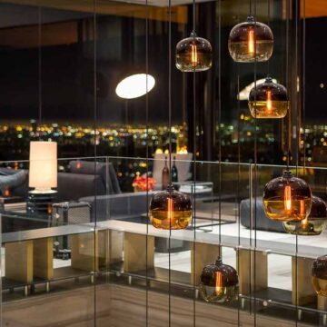 Modern interior with stylish pendant lights and a panoramic night city view, captured by Coldea Productions as part of their real estate photography services