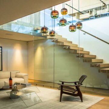 Modern interior living room with a floating staircase and stylish lighting, showcasing Coldea Productions' real estate photography services.