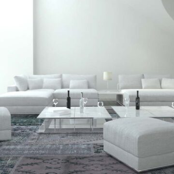 Modern living room with sleek white furniture and decor, showcasing real estate photography services by Coldea Productions.