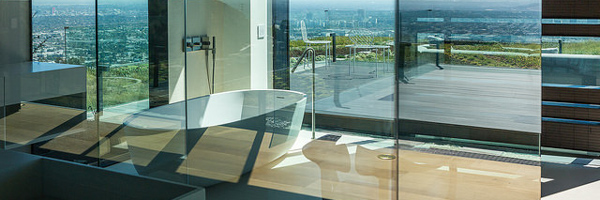 A luxurious bathroom with a freestanding tub and floor-to-ceiling windows offering breathtaking views of Manhattan Beach, CA, captured by Coldea Productions' real estate video and photography services.