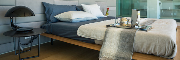 Modern bedroom interior with luxury decor, featuring a cozy bed setup, bedside lamp, and stylish tray, captured by Coldea Productions.