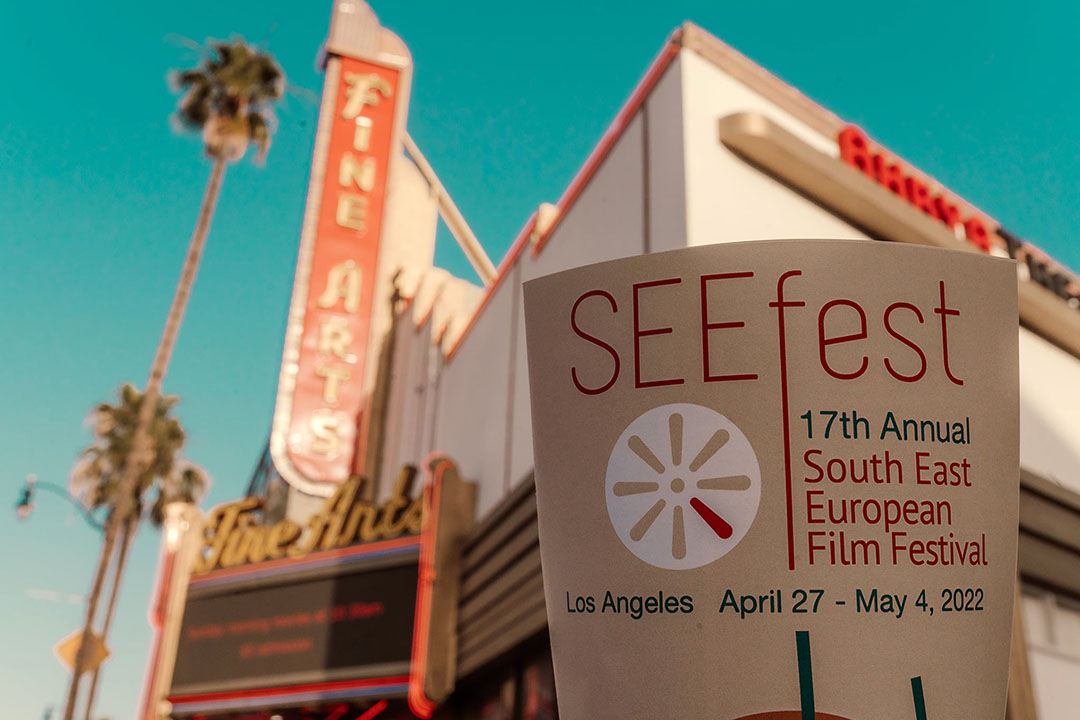 A poster for the 17th Annual South East European Film Festival (SEEfest) held in Los Angeles in front of the Fine Arts Theatre. The bright sunny day complements the vibrant retro sign of the theatre.