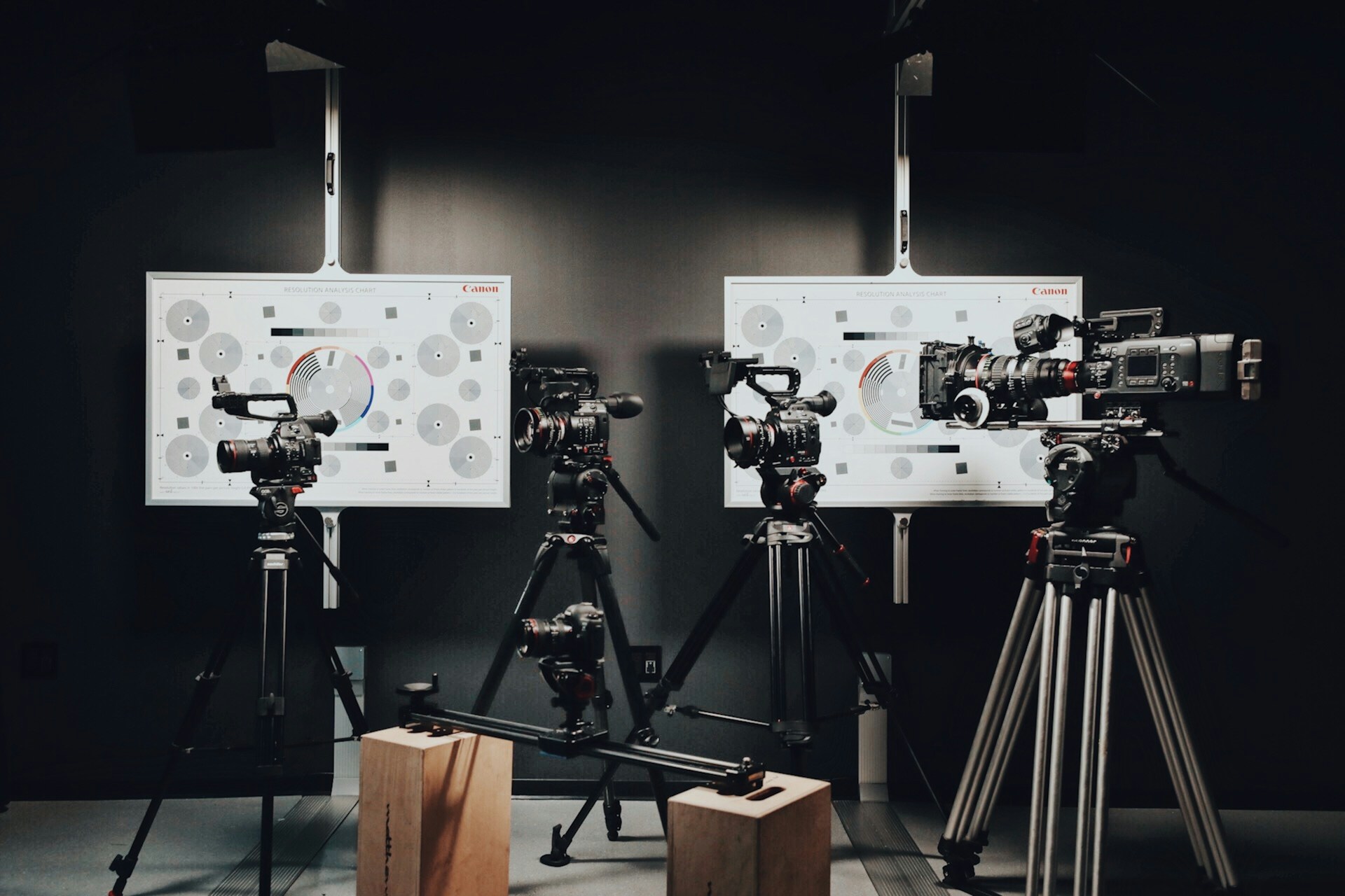 Camera on a video slider, four video cameras on tripods, and two high-quality calibration targets set up for a corporate video shoot.