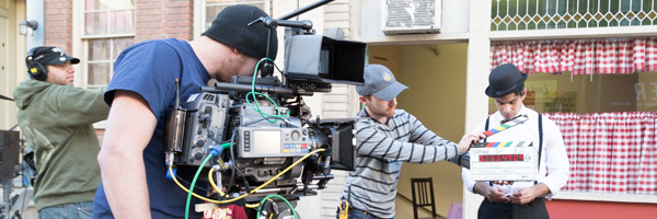 Camera crew filming an actor on a city set, representing Coldea Productions' video commercial services in Loma Linda, California