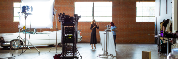 Behind-the-scenes setup on a commercial video shoot in Lake Irvine, California, with Coldea Productions crew, lighting, and classic car in the background.