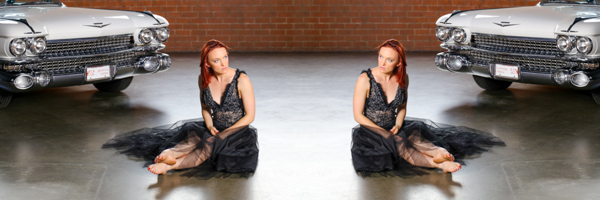 Dancer in black dress sitting beside a classic Cadillac on a video commercial set in Lake Forest, California, produced by Coldea Productions.