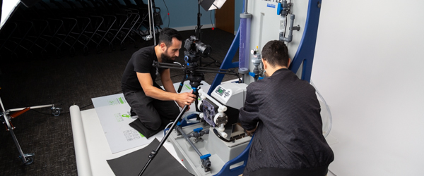 Alexis Mendez and Alex Stoica from Coldea Productions capturing a Blue-White Peristaltic Metering Pump in a detailed product video shoot.