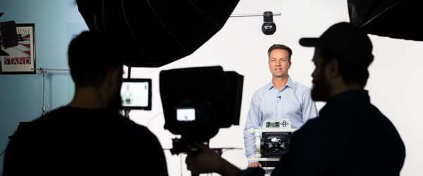 Behind-the-scenes look at a video production agency filming a professional on set.