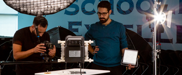 Alexis Mendez and Alex Stoica of Coldea Productions filming a Blue-White Peristaltic Metering Pump in a professional product video setup.