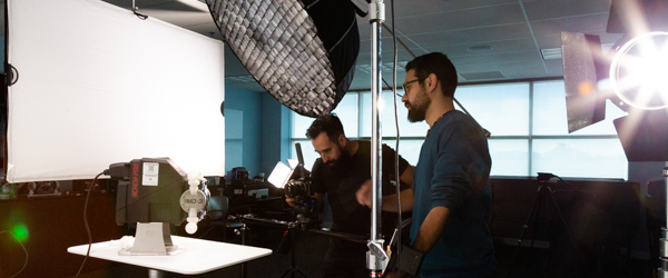 Alexis Mendez and Alex Stoica of Coldea Productions filming a Blue-White Peristaltic Metering Pump during a product video shoot.