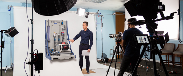 A professional video production set with a presenter explaining industrial equipment, representing Coldea Productions' full-service video production expertise.