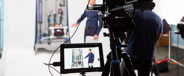 Rob Gledhill from Blue-White Industries presents a Plastic Chemical Feed Skid, while Alexis Mendez from Coldea Productions captures the demonstration on video.