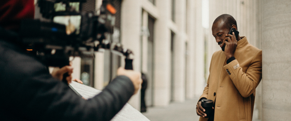 Coldea Productions filming a commercial scene with a professional model on the phone outdoors.