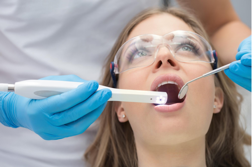 Dentist performing an oral examination using advanced tools, representing how dentists are using video marketing to showcase modern dental practices and patient care